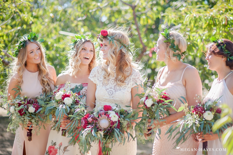 bohemian-bridesmaids-wearing-mismatched-dresses-while-bride-wears-open-back-lace-gown