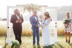 gorgeous-bride-and-groom-with-their-baby-at-the-altar-at-figueroa-mountain-farmhouse-wedding-in-california