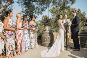 magical-ceremony-at-saddlerock-ranch-bridesmaids-wears-floral-dresses-bride-wearing-a-long-sleeve-backless-lace-wedding-gown